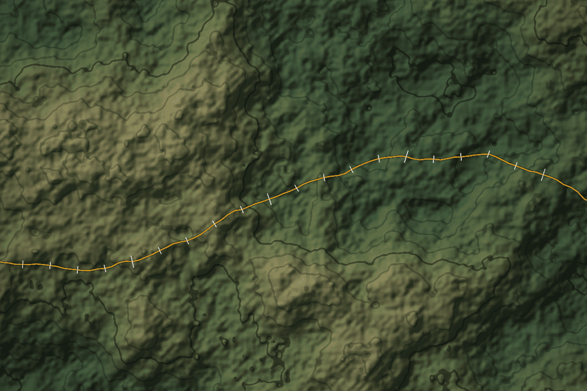 Surveyed route with stationing ticks crossing hillshade terrain